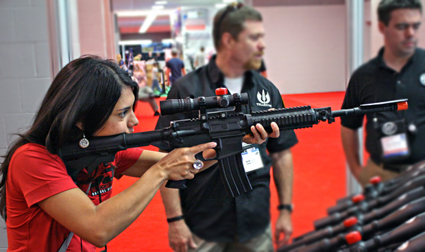 Top Shot's Gabby Franco tries out a scope at the NRA Convention in St. Louis, Missouri.