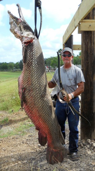 Crawford stands next to his giant alligator gar