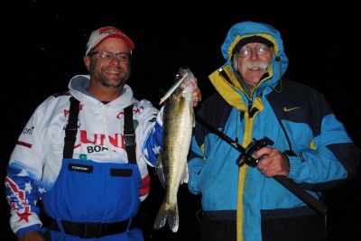 Mark Martin holds a walleye that Eric Sharp, right, caught on Muskegon Lake.