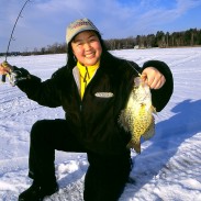 Kristi Takasaki with a beautiful crappie caught in bright sunshine, but with a glow jig! Image by Ted Takasaki.