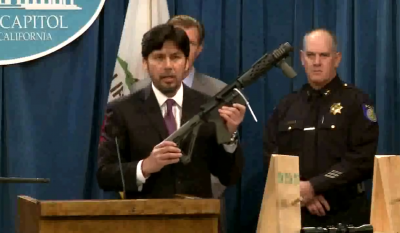 Senator Kevin de Leon holds up a self-assembled rifle, one of the many that the new legislation could affect.